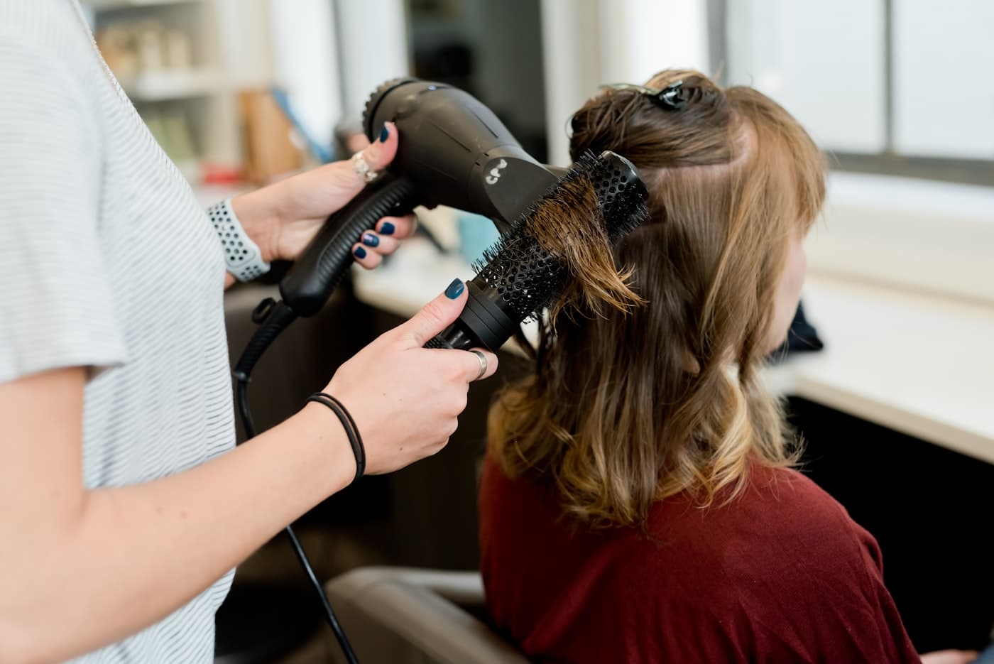 Hairstylist applying ammonia-free hair colour during a home root touch-up in Jaipur