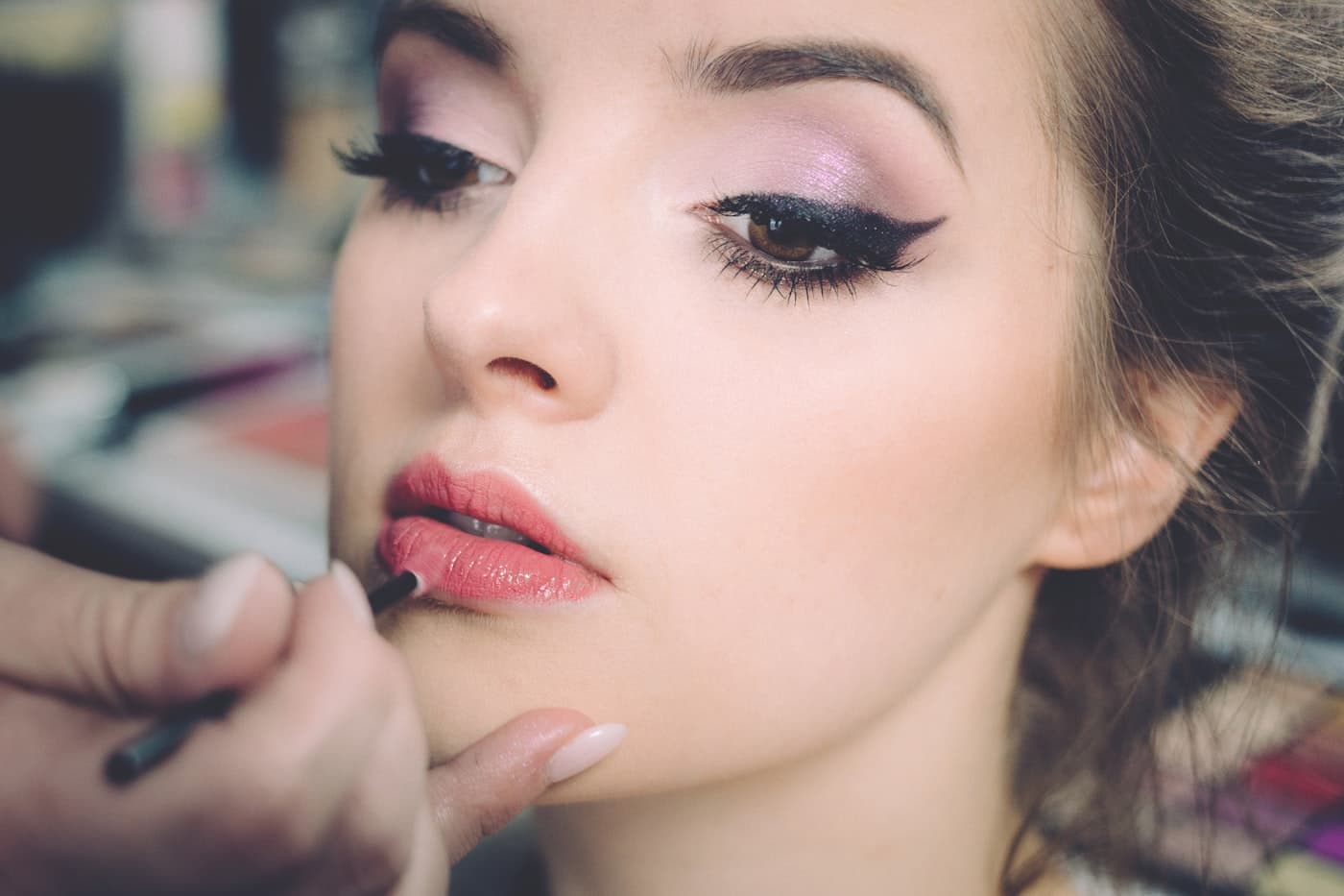 Makeup artist applying party makeup to a client at home in Jaipur